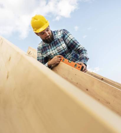 worker-with-hard-hat-level-checking-roof-timber-house